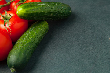 Tomatoes, cucumbers on a dark background. food concept. close up. Empty space for text.