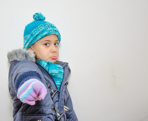 Niña rubia con ropa de abrigo en invierno
