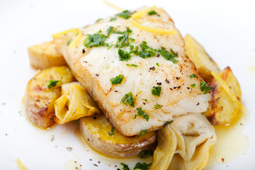 Roasted cod, codfish with baked potatoes and artichokes with lemon and herbs sauce
