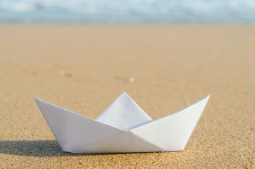 white paper boat on beach