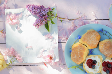 Beautiful, spring breakfast background with Scottish scones, lilac  and cherry flowers