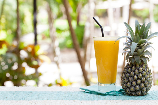 Glass of pineapple smoothie, juice and fresh fruit