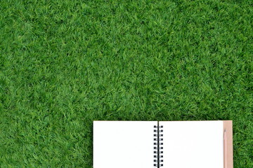 Blank book and pencil on the lawn with copy space for text