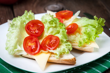 Delicious sandwich with tomatoes, cheese and lettuce.