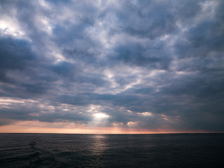 view of sea during sunset with cloudy sky.