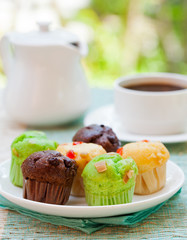 Assortment of muffins vanilla, chocolate, pandan on a white plate