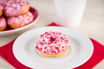 Donuts mit pinker Glasur und einer Tasse Kaffee