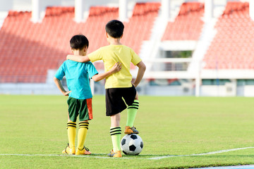 Boy and football in the football grass field