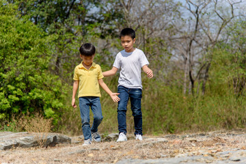 Two Boy walking on the rocky land.