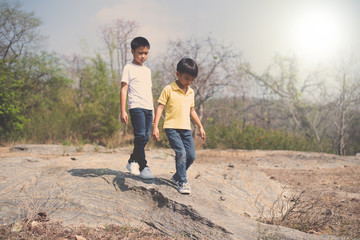 Obraz na płótnie Canvas Two Boy walking on the rocky land.