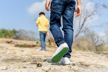 Two Boy walking on the rocky land.