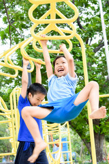 Boy play with hang yellow bar.