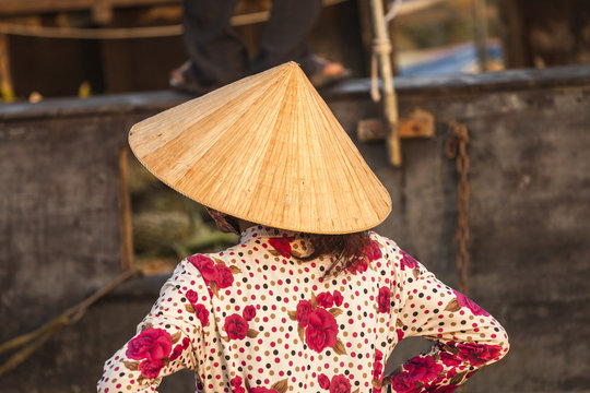 Shoulders vietnamese woman with typical conical hat in the floating market of Can Tho, in the Mekong delta. Vietnam