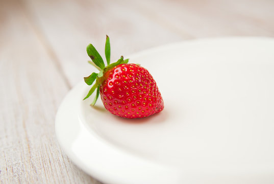 Ripe strawberry fruit on a white plate