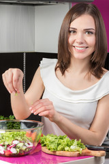 Young female cook making a fresh salad