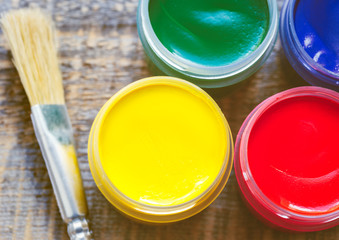paint cans with brush on a wooden background top view