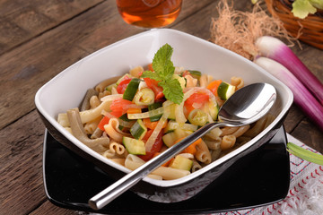 Pasta dish with black background and fresh vegetables