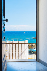 Summer. Sea views from the open door of the apartment for the weekend. Mediterranean coast in Italy.