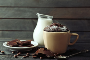 Chocolate fondant cake in cup on wooden background