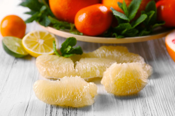 Set of different citrus fruit on light wooden background