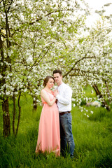 Couple in love under blooming branches spring day.