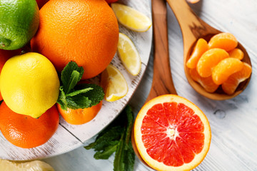 Set of different citrus fruit on light wooden table