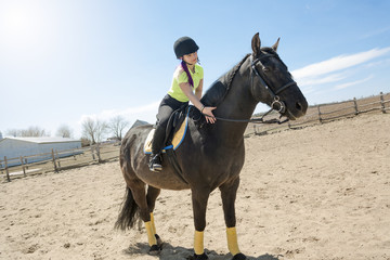 Beautiful teen girl on the farm with her horse.