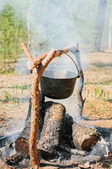 The fire near the camp. Cooking food on a fire. Journey into the wild concept.
