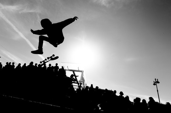Man making trick by skateboard in the air. High jump by skate. Free space for a text. Extreme sport concept. Black and white picture.