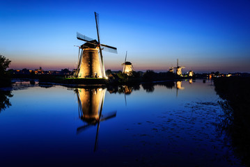 Windmills at dusk under a blue sky