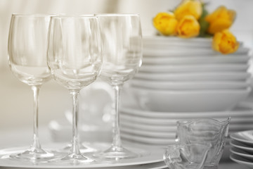 Set of dishes with yellow tulips for dinner party, close up