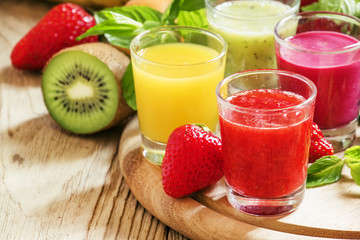 Colorful summer fruit and berry juices and smoothies in glasses: