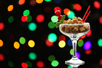 Margarita glass with brown lump sugar on dark bokeh background