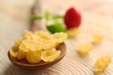 Dry gnocchi pasta in wooden spoon on a table