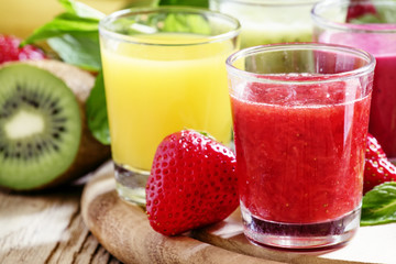 Colorful summer fruit and berry juices and smoothies in glasses: