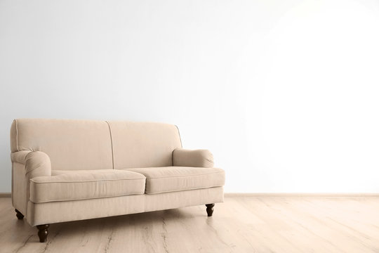 Cozy couch on wall background