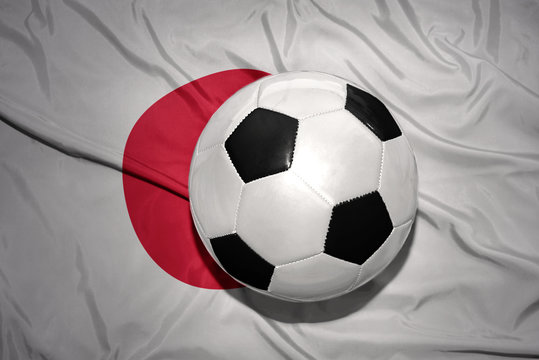 black and white football ball on the national flag of japan