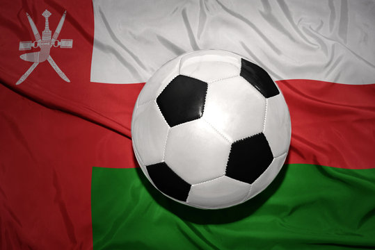 black and white football ball on the national flag of oman