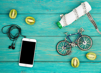 bicycle model, headphones, smartphone, kiwi, bottle of water