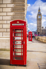 Fototapeta na wymiar London, UK - Iconic Red British telephone box with Big Ben on a sunny afternoon