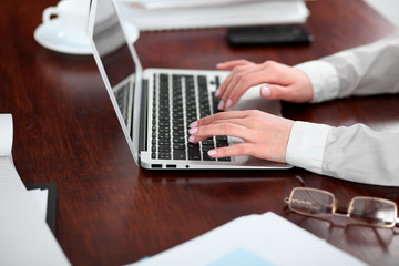 Close up of business woman hands typing on laptop computer