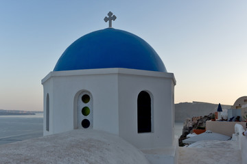 Fototapeta na wymiar Church with blue roof in town of Oia and panorama to Santorini island, Thira, Cyclades, Greece