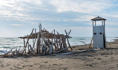 Fototapeta na wymiar spiaggia con torretta e capanna di legno secco