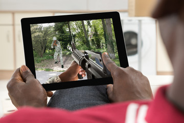 Man Playing Action Game On Digital Tablet