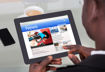 Fototapeta na wymiar Businessperson Reading News On Digital Tablet