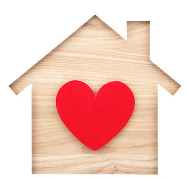 House shaped paper cutout and heart on natural wood lumber.
Isolated on white background.
