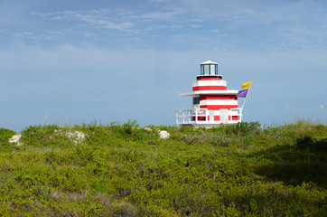 Summer landscape with a colorful lifeguard house
surrounded by blue sky and green foreground