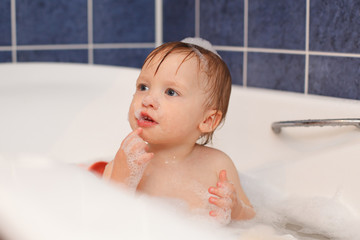 Baby in the bathroom with foam bath