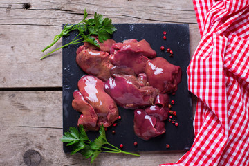Raw chicken liver on slate board - obrazy, fototapety, plakaty