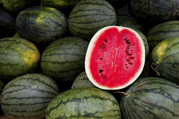 watermelon slice.Many big sweet green watermelons and one cut watermelon.